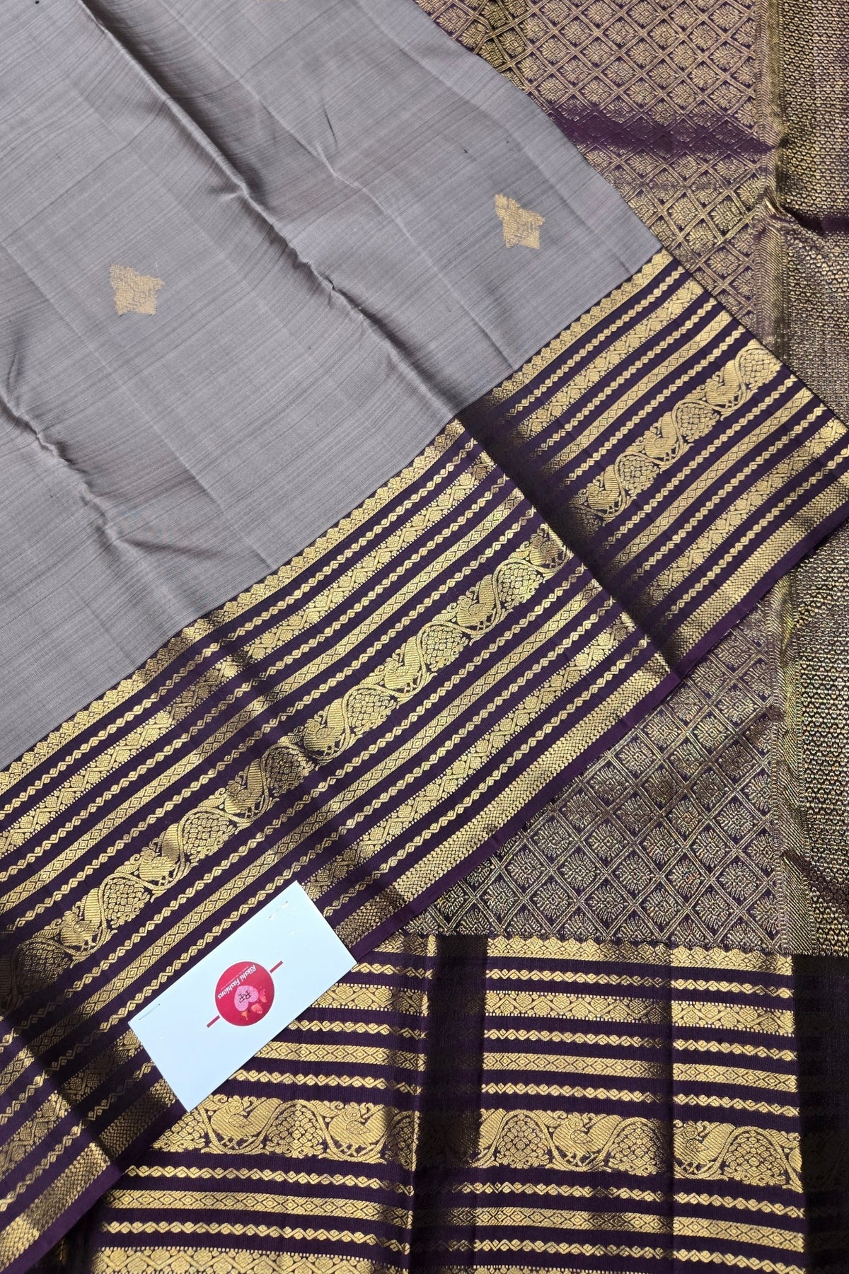 Gray fabric with gold and purple stripes and a brand tag.