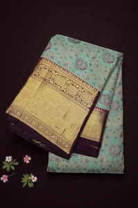 Teal fabric with gold embroidery on a dark background