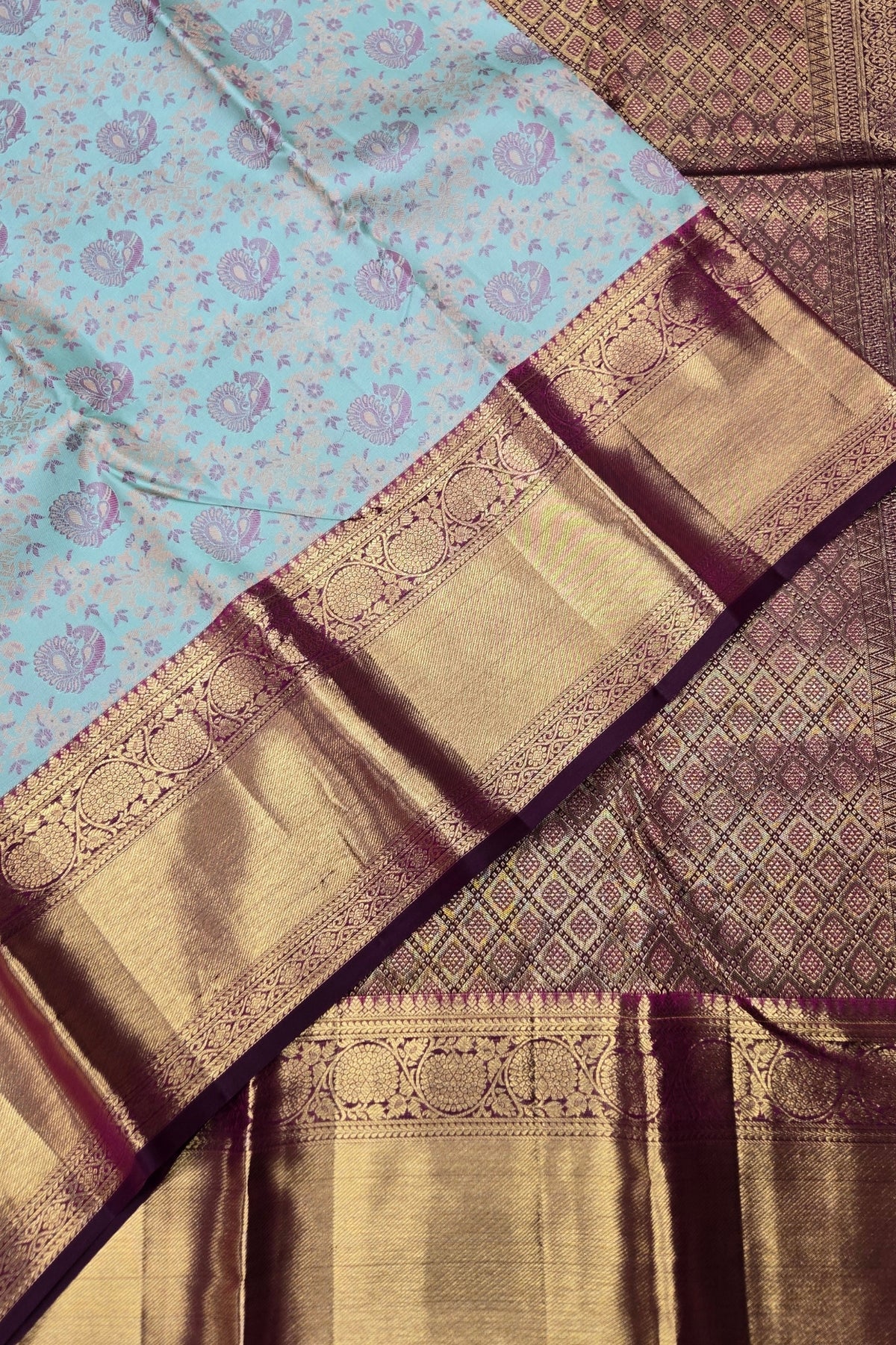 Close-up of a traditional saree with a blue and gold pattern.