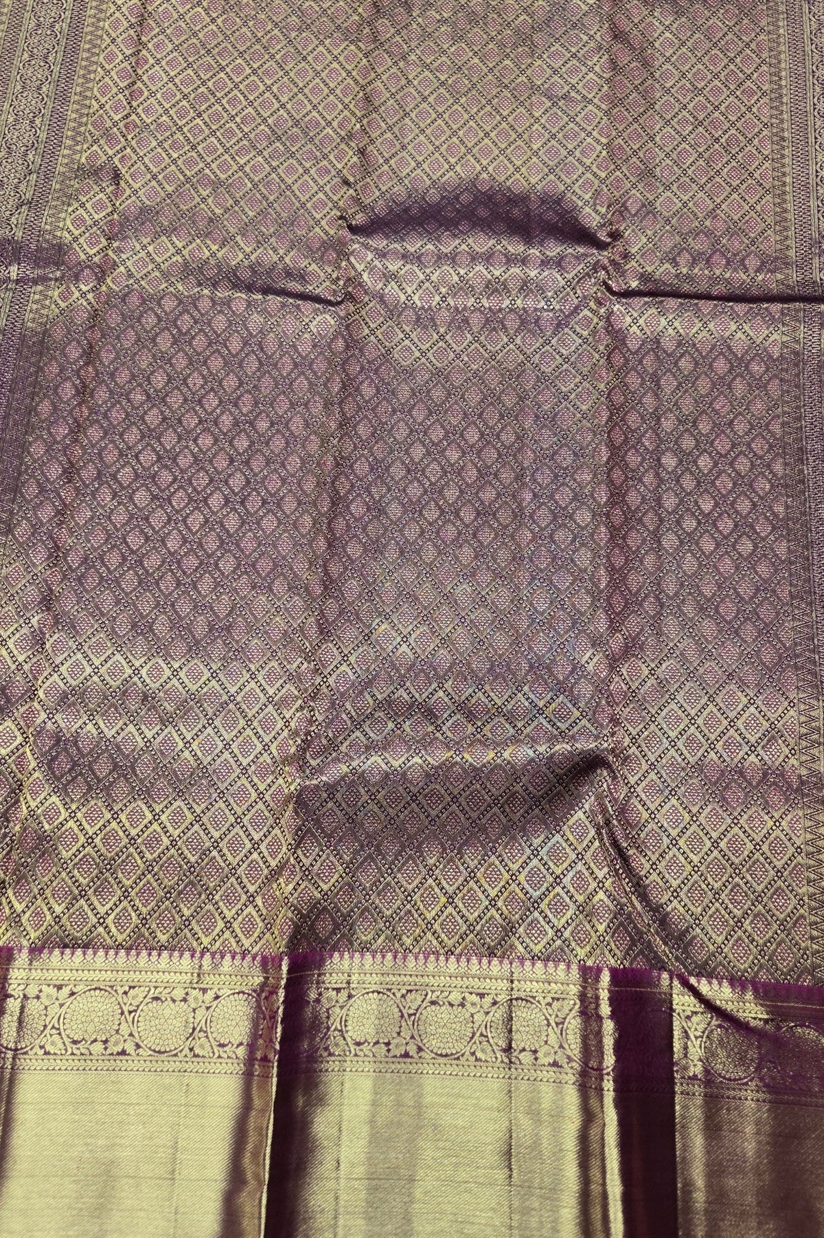 Textured fabric with a diamond pattern in shades of gray and green.