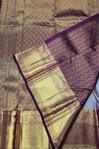 Close-up of a purple and gold saree with intricate patterns
