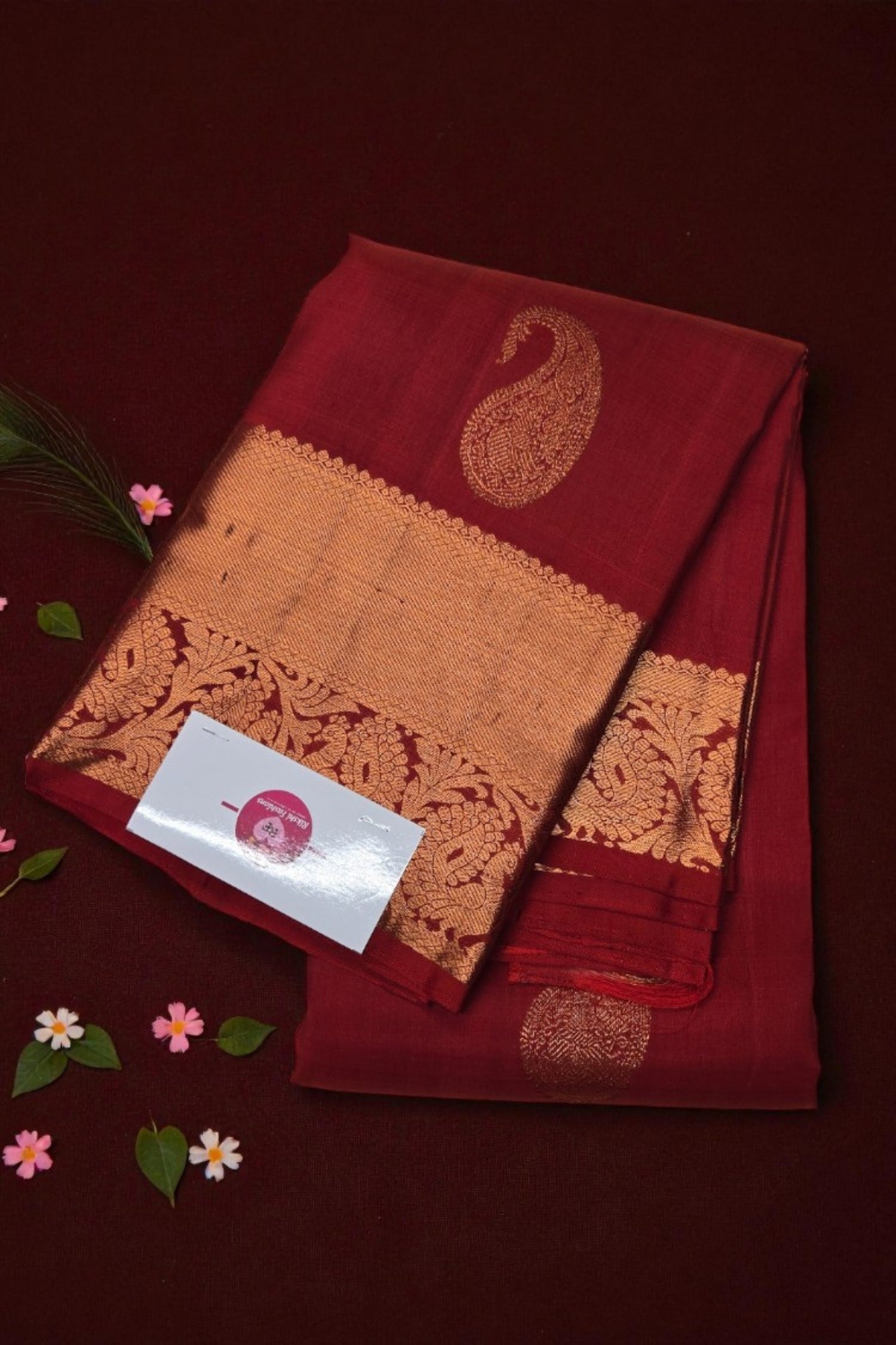 Red and orange saree with floral patterns on a dark red background