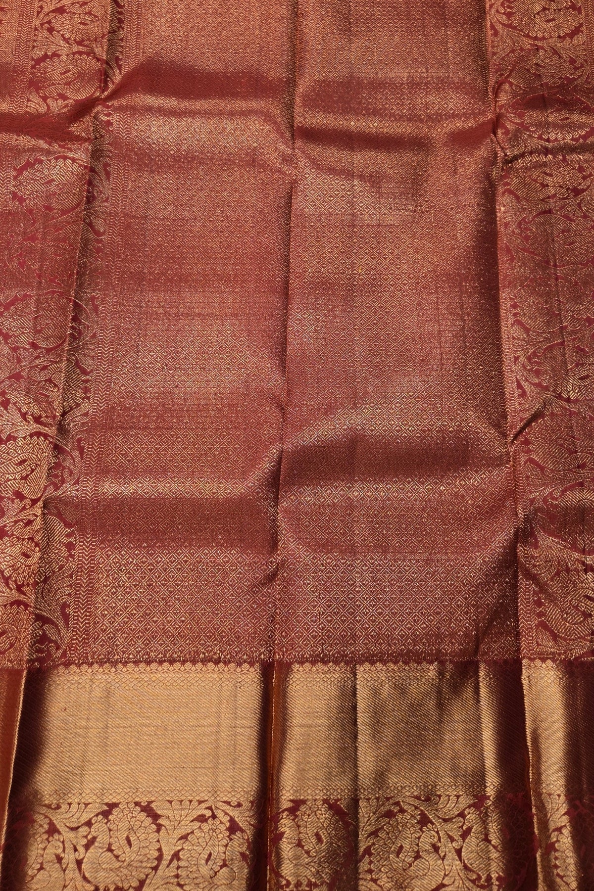 Close-up of a brown and gold saree with intricate patterns