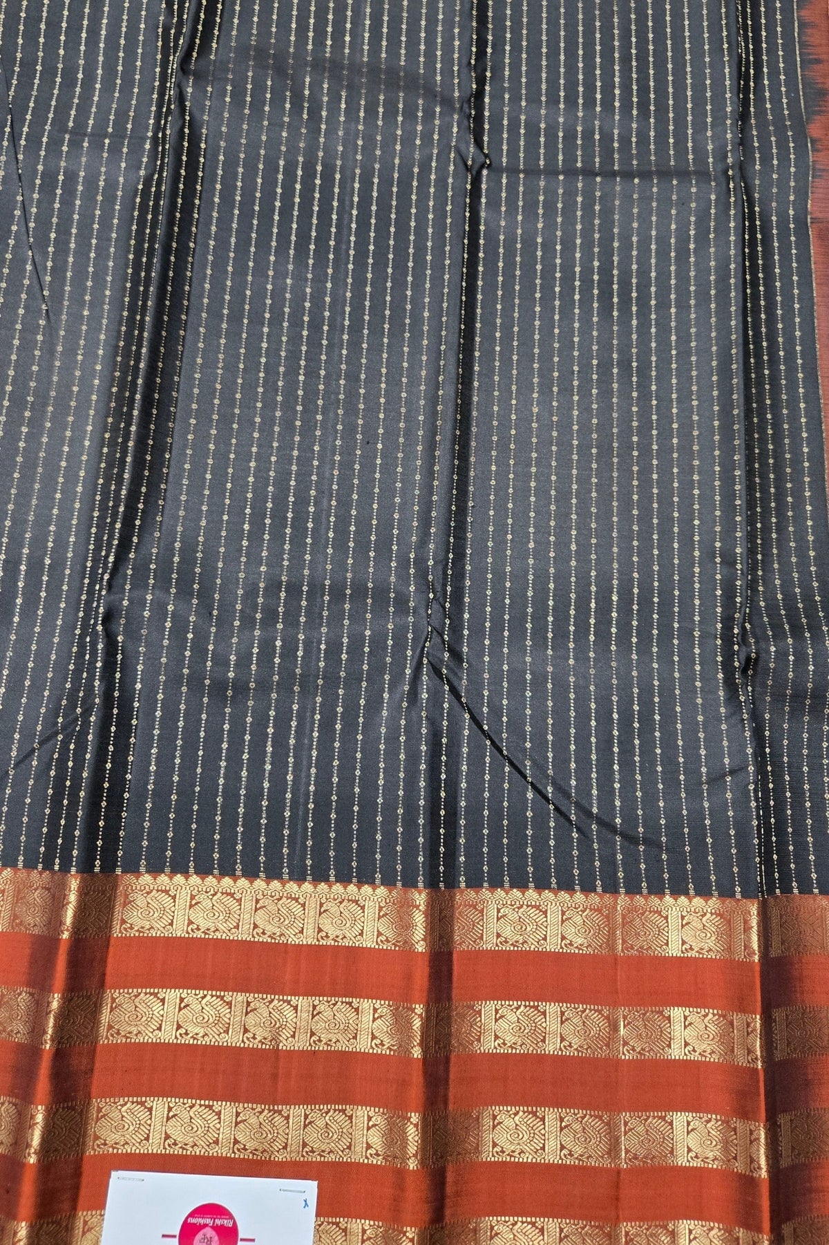 Black and red patterned fabric with a visible brand label.