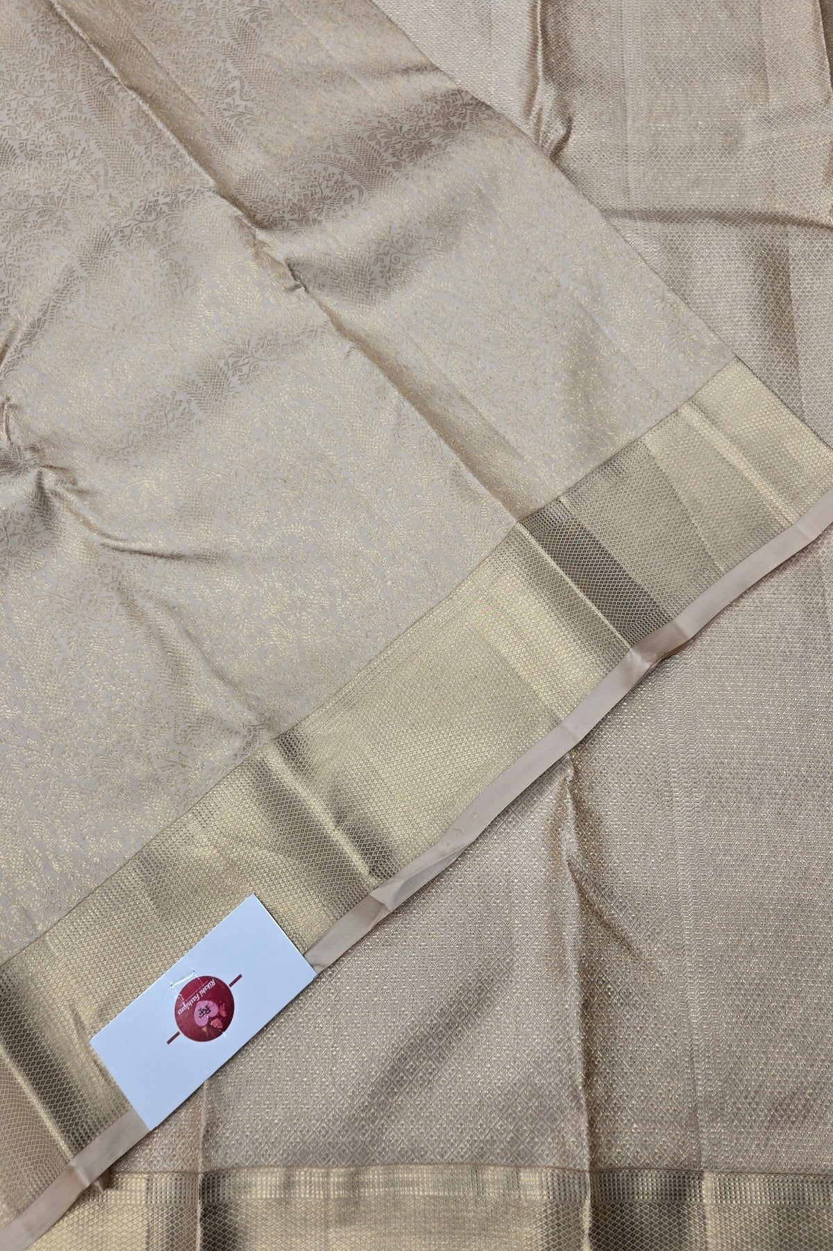 Beige saree with a subtle pattern and a visible brand label.