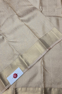 Beige saree with a subtle pattern and a visible brand label.