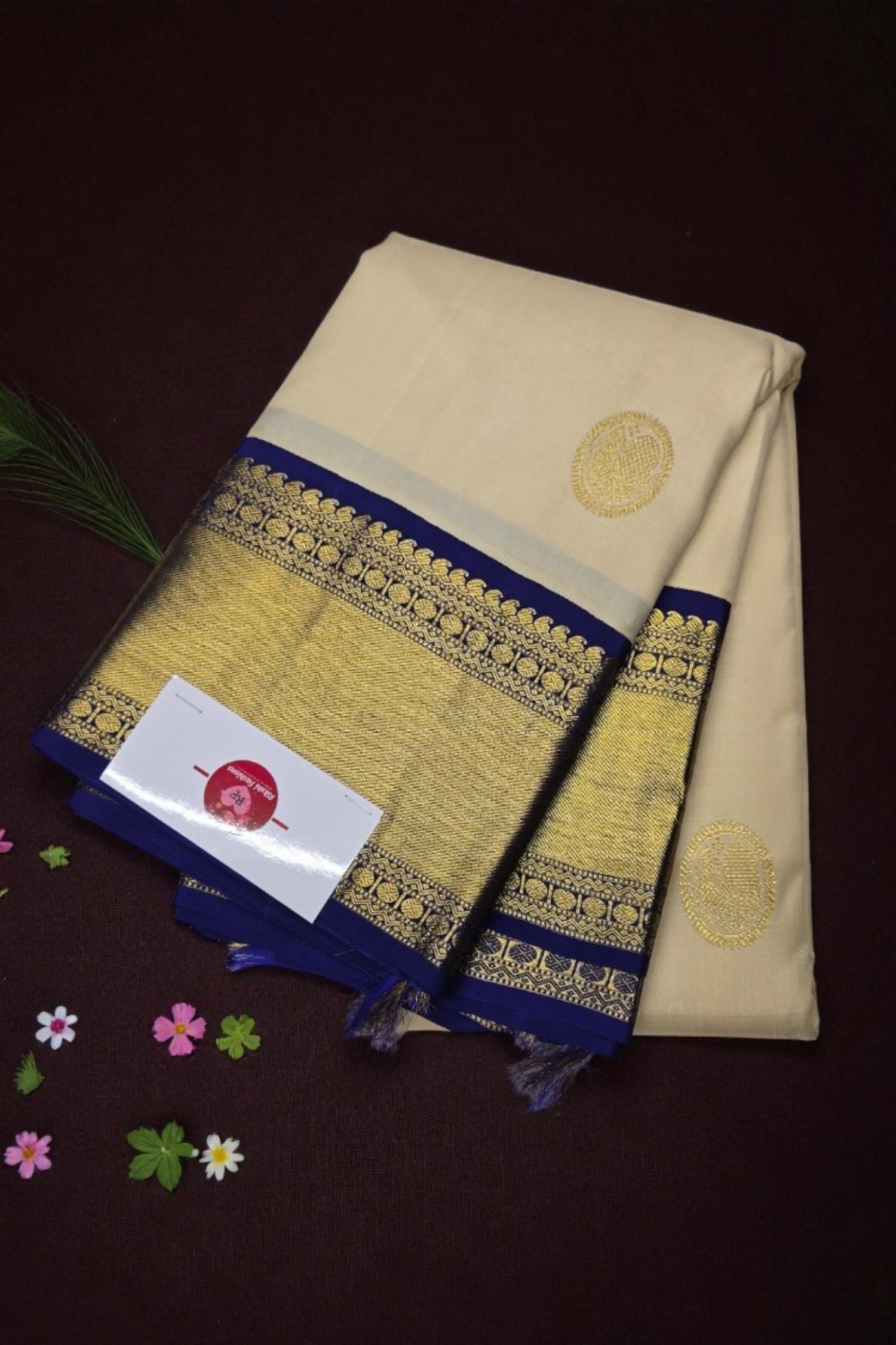 Beige saree with gold and blue border on a dark background