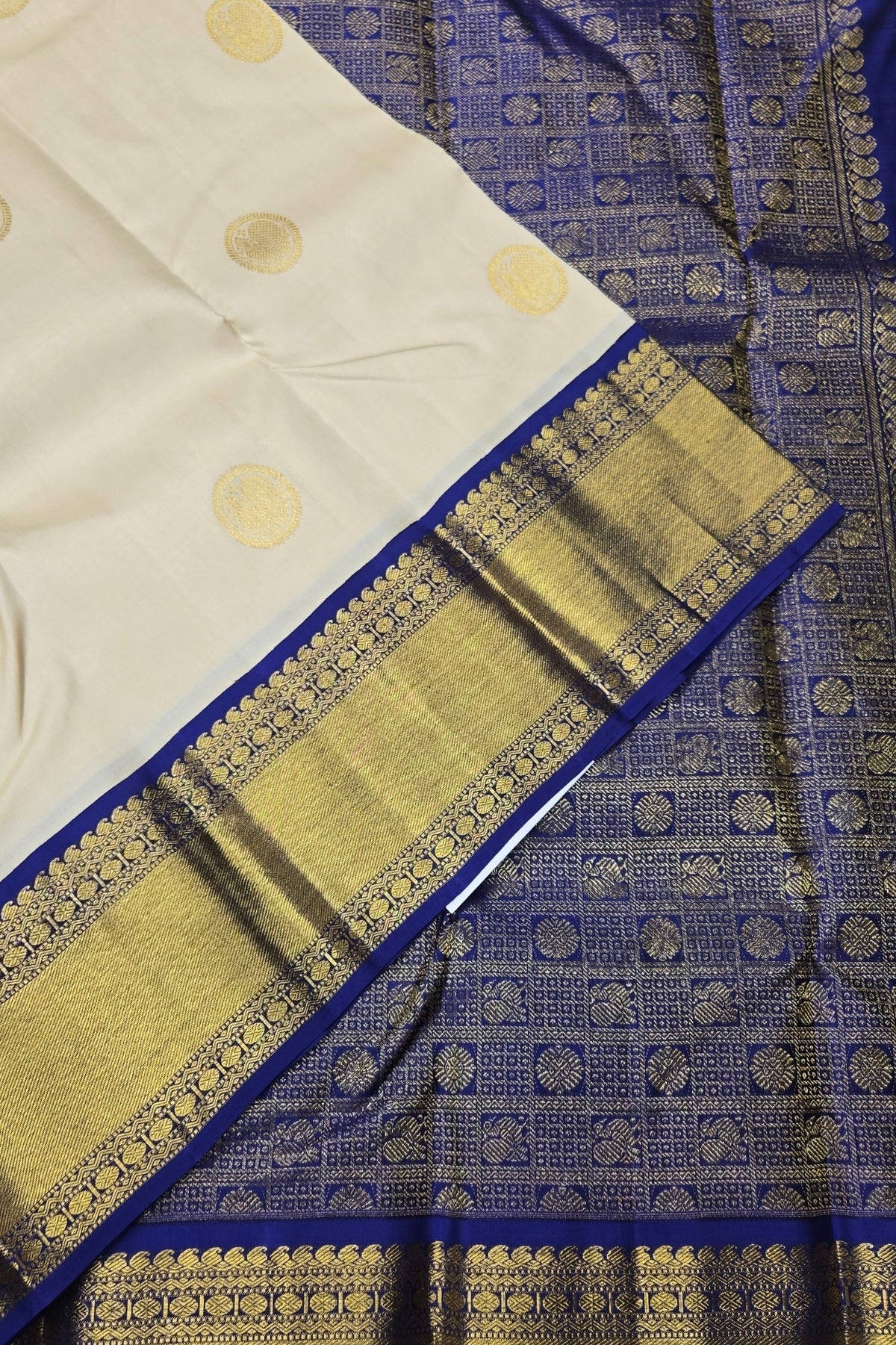 White fabric with gold patterns and blue border