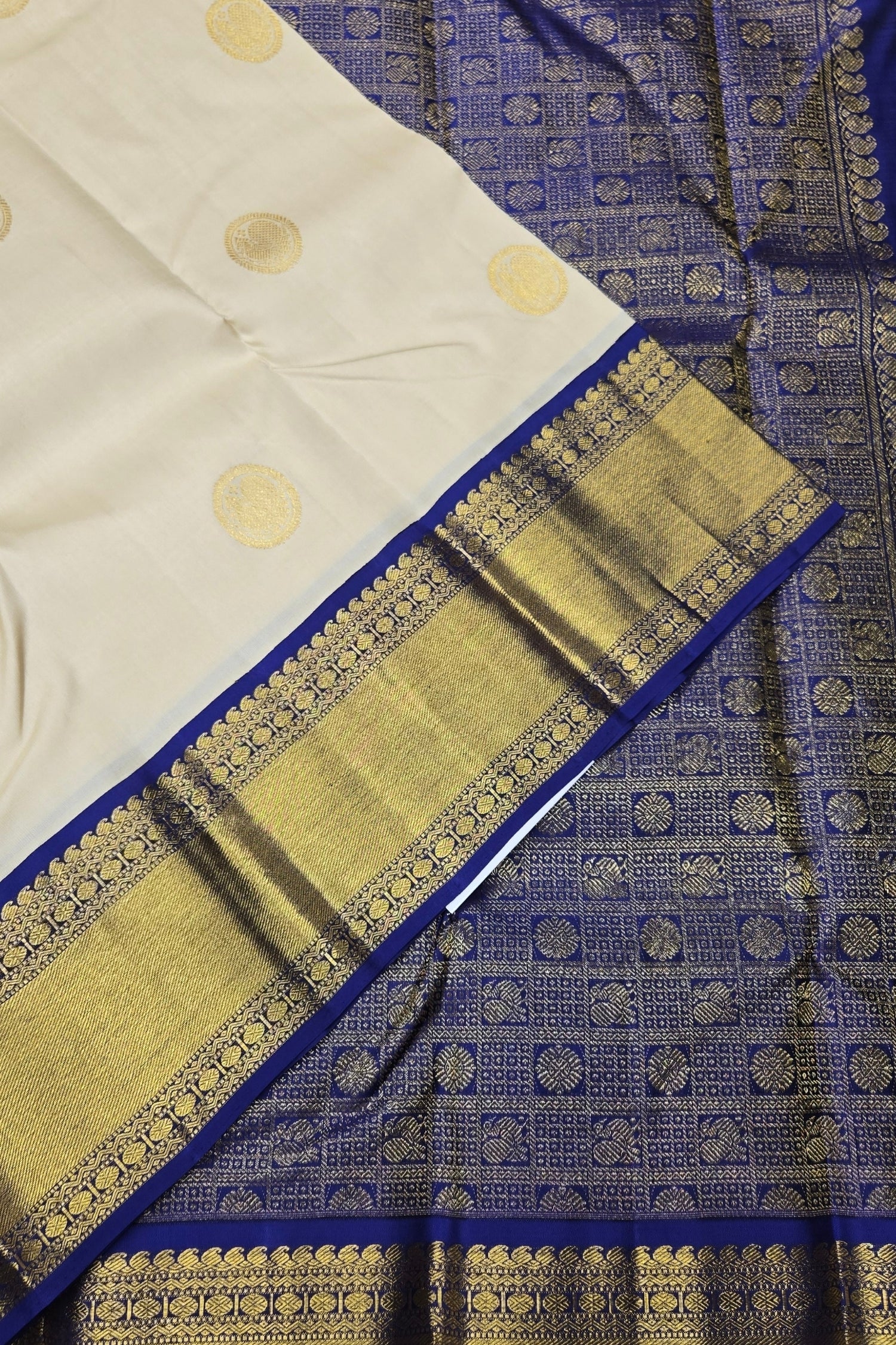 White fabric with gold patterns and blue border