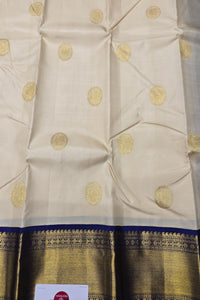 Beige fabric with gold circular patterns and a blue border