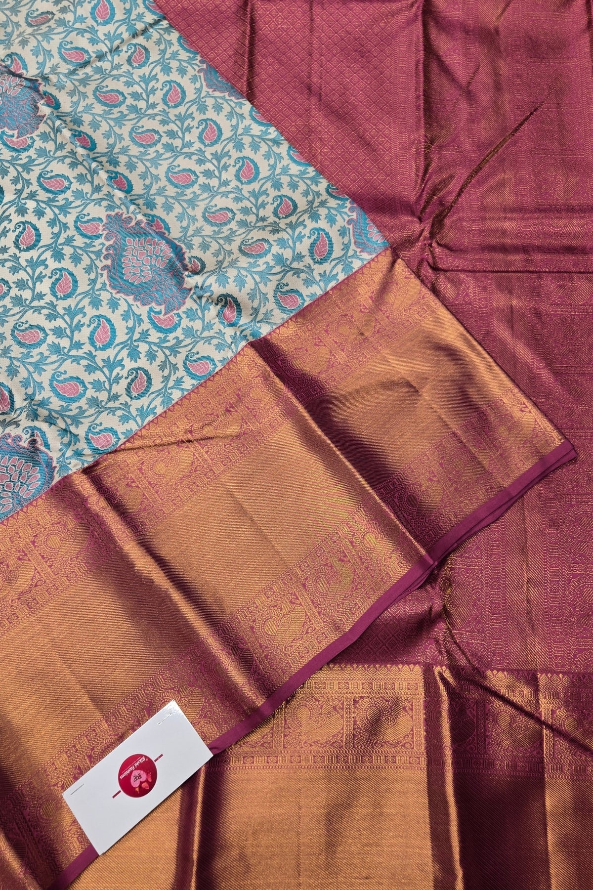 Close-up of a fabric with a patterned section and a maroon background.