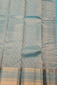 Close-up of a light blue fabric with intricate patterns and a border.