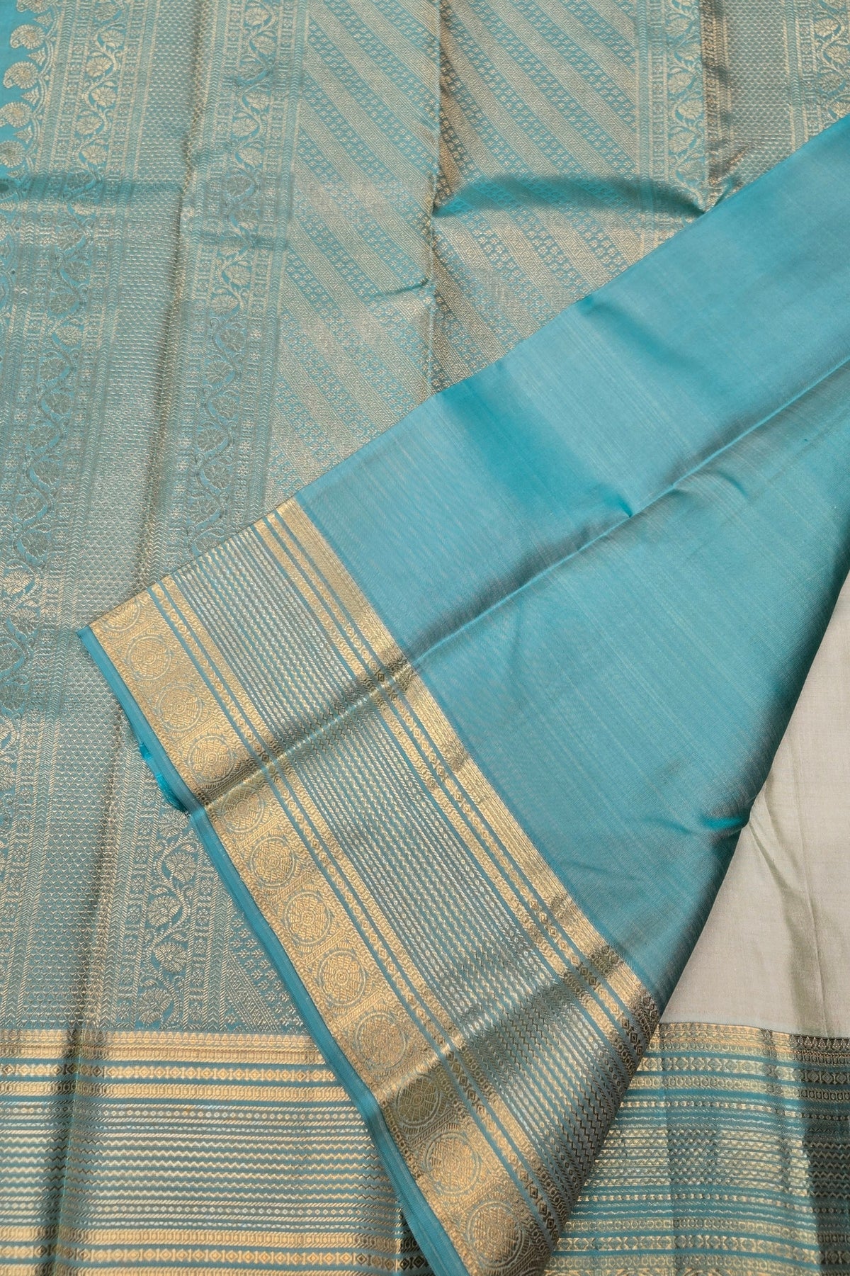 Blue and white fabric with gold border on a textured background