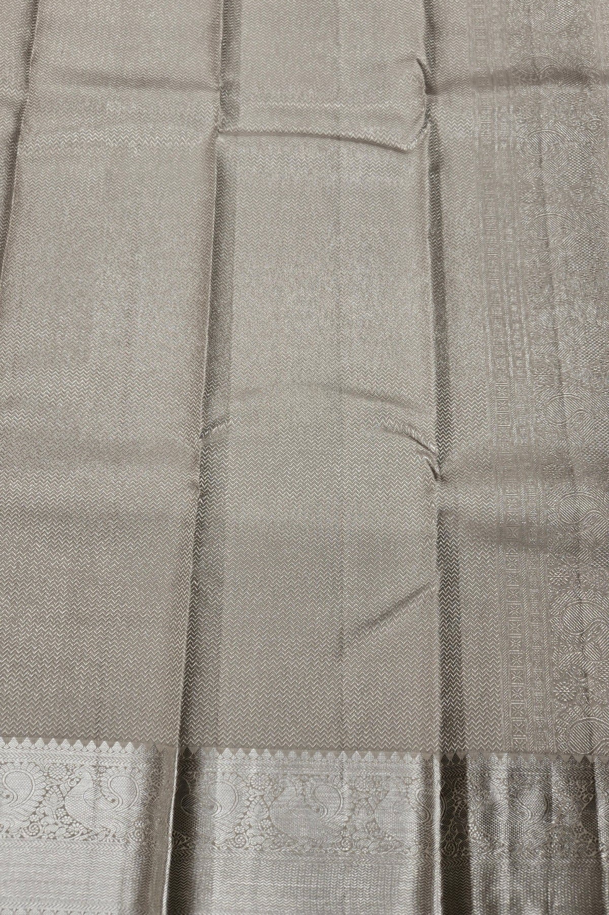 Close-up of a gray saree with a woven pattern