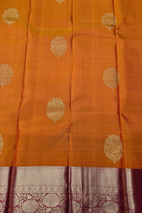 Orange fabric with gold circular patterns and a maroon border