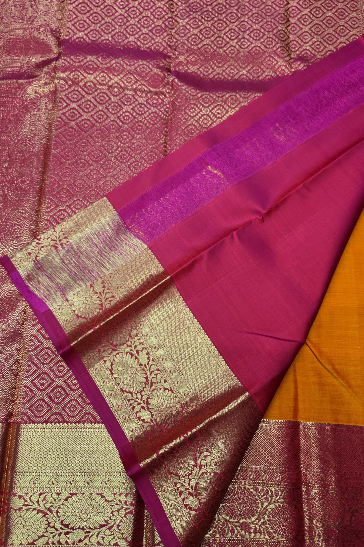 Saree with pink and gold patterns on a textured fabric background