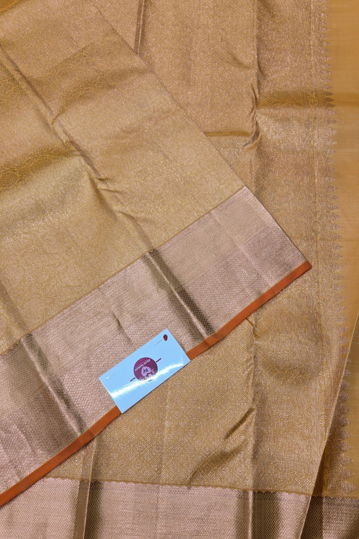 Close-up of a brown fabric with a visible brand label on a wooden surface