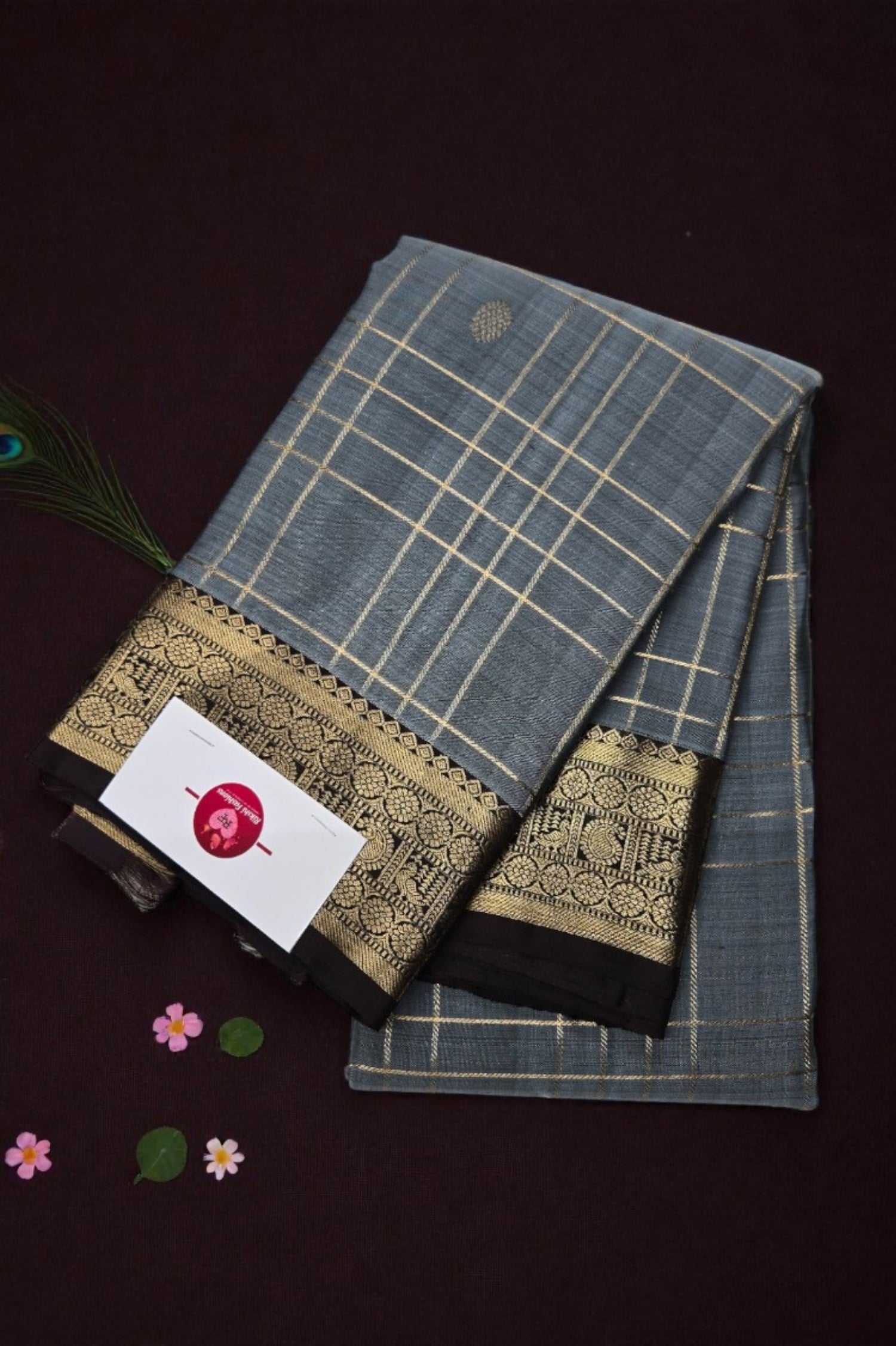 Traditional saree with a grid pattern and decorative border on a dark background
