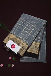 Traditional saree with a grid pattern and decorative border on a dark background
