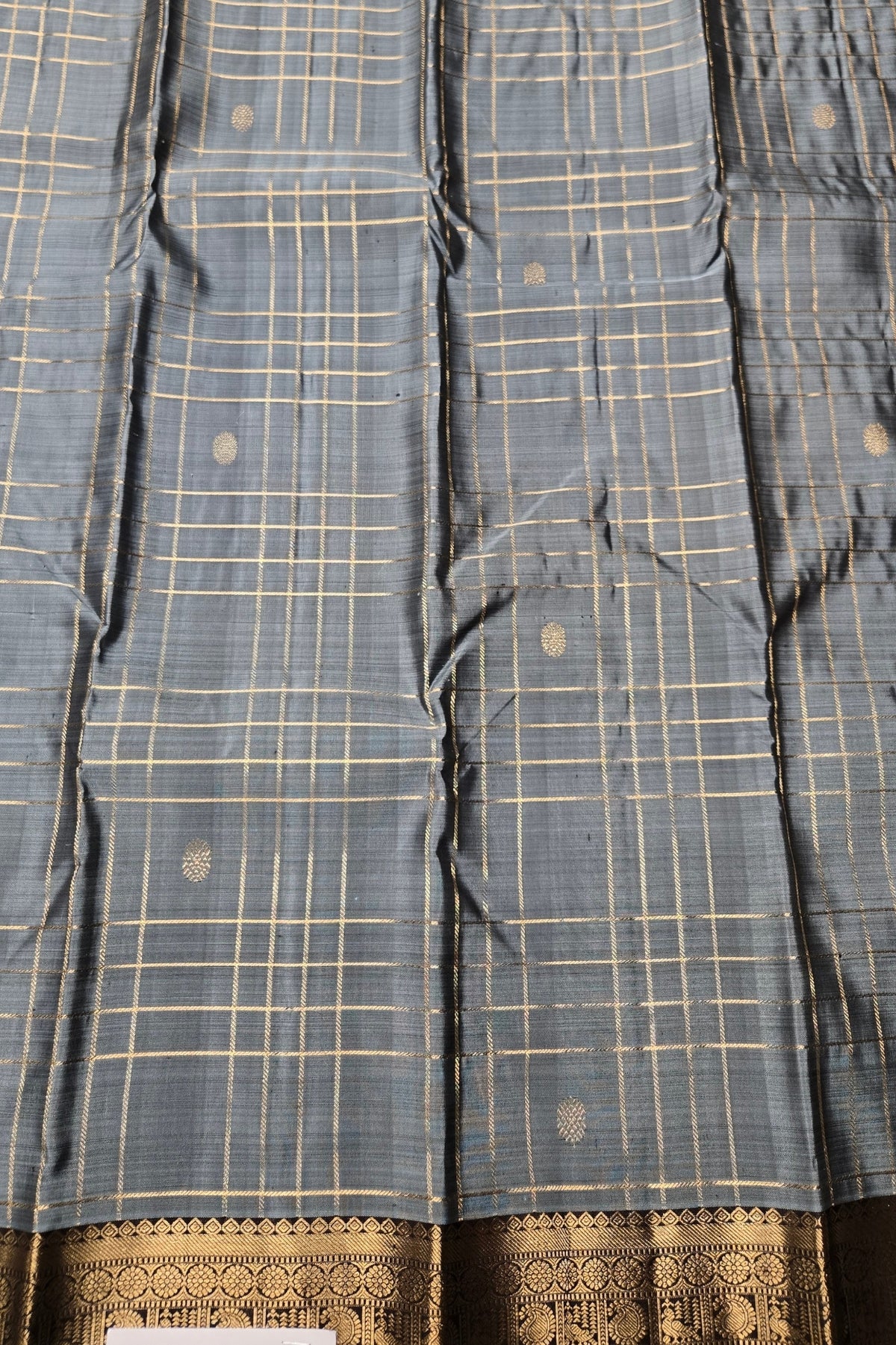 Blue checkered fabric with gold patterns and a decorative border.