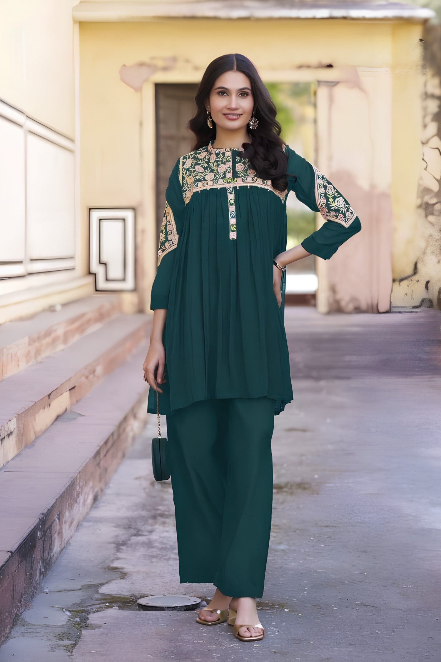 Woman in a green traditional outfit standing outdoors.