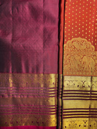 A close-up of a richly woven Indian silk saree, showcasing a deep magenta body with a wide golden zari border and a contrasting orange-pink pallu featuring an elephant motif and gold patterns.