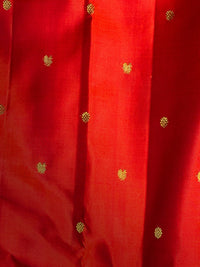 A close-up of a vibrant red fabric, likely silk or satin, featuring a vertical pleated texture and scattered small gold woven floral motifs.