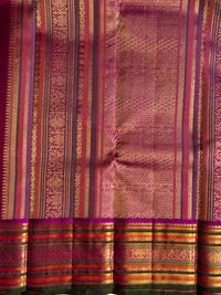 A close-up of a richly patterned silk saree body with a wide border, featuring metallic gold zari work, stripes of magenta, pink, orange, and green, and a deep magenta border.