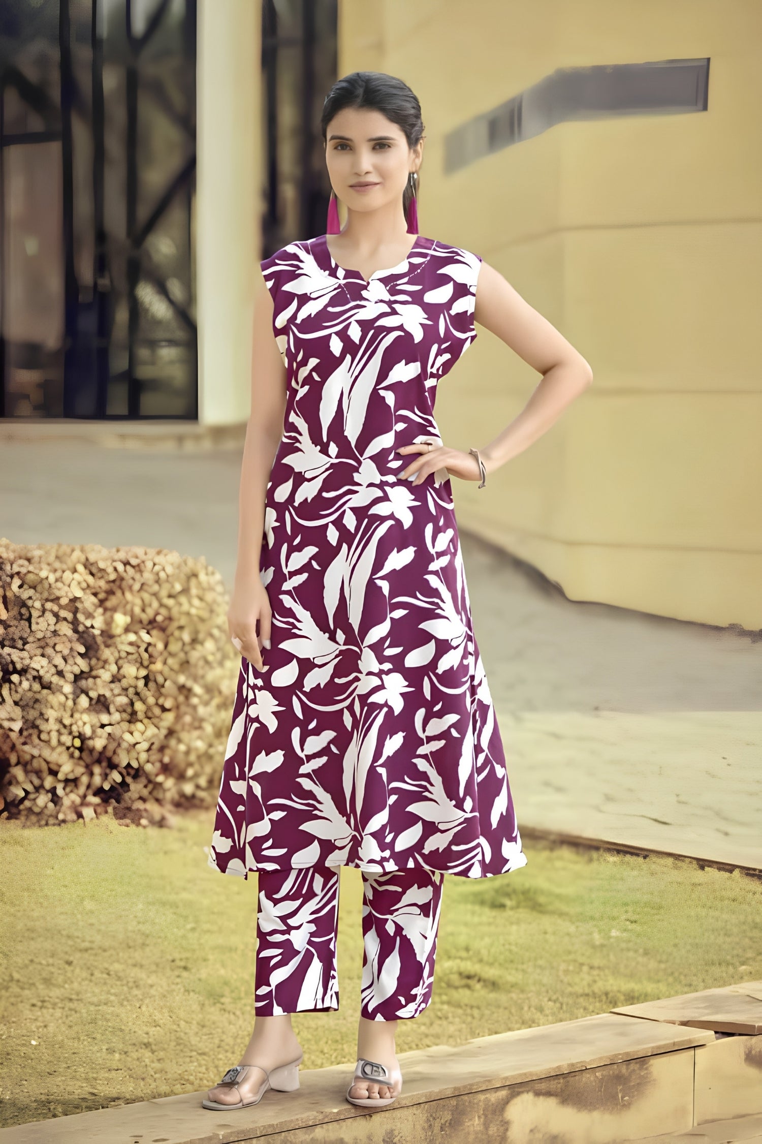 Woman wearing a purple and white floral dress standing outdoors.