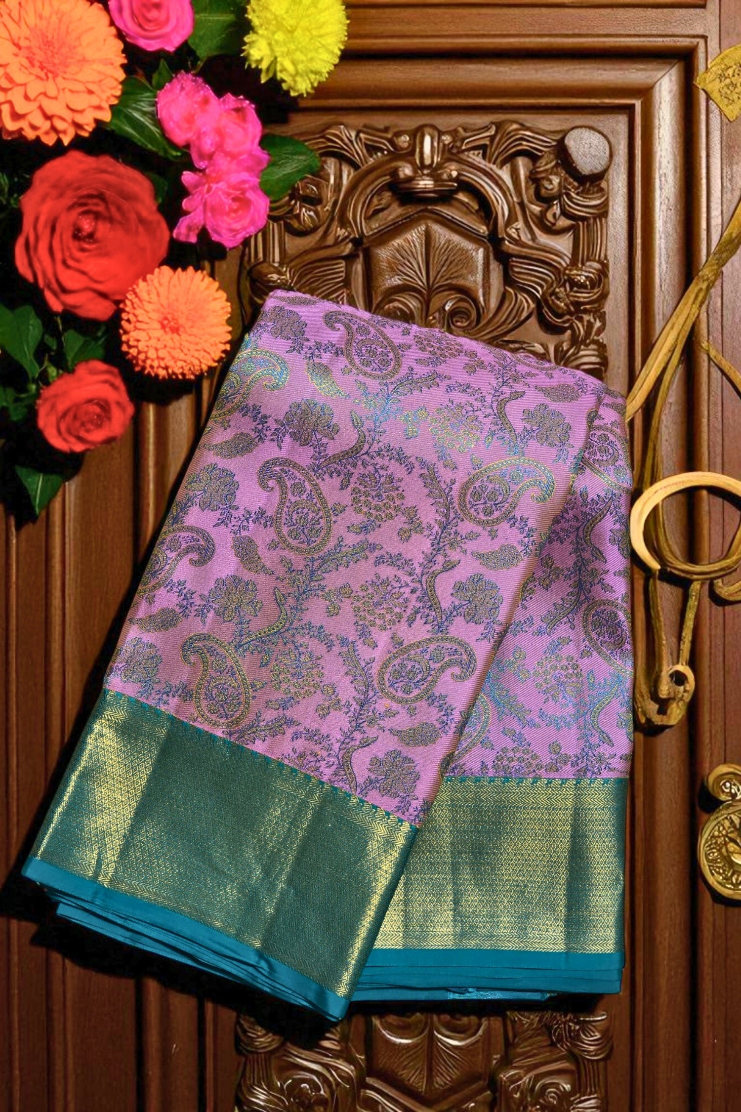 Purple and green saree with floral decorations on a wooden door
