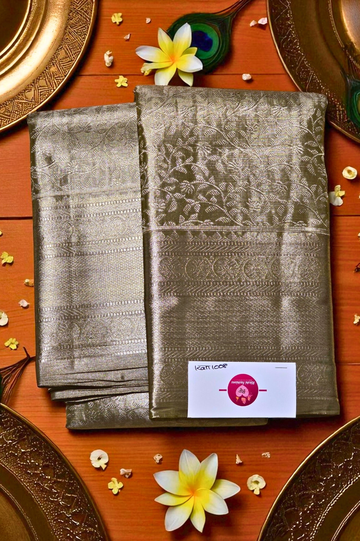 Two folded sarees on a wooden surface with decorative elements