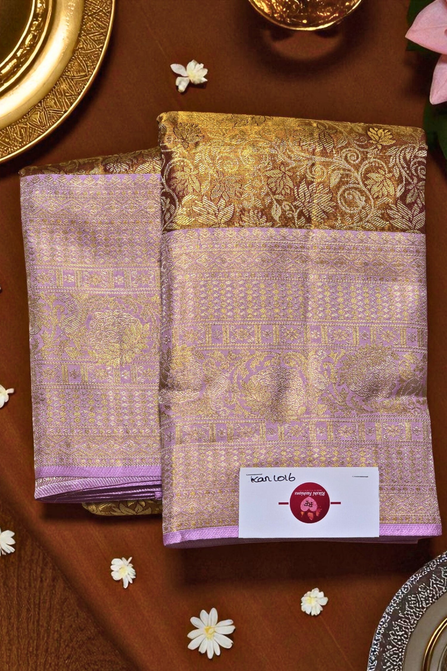 Purple and gold patterned fabric with a brand label on a brown surface.