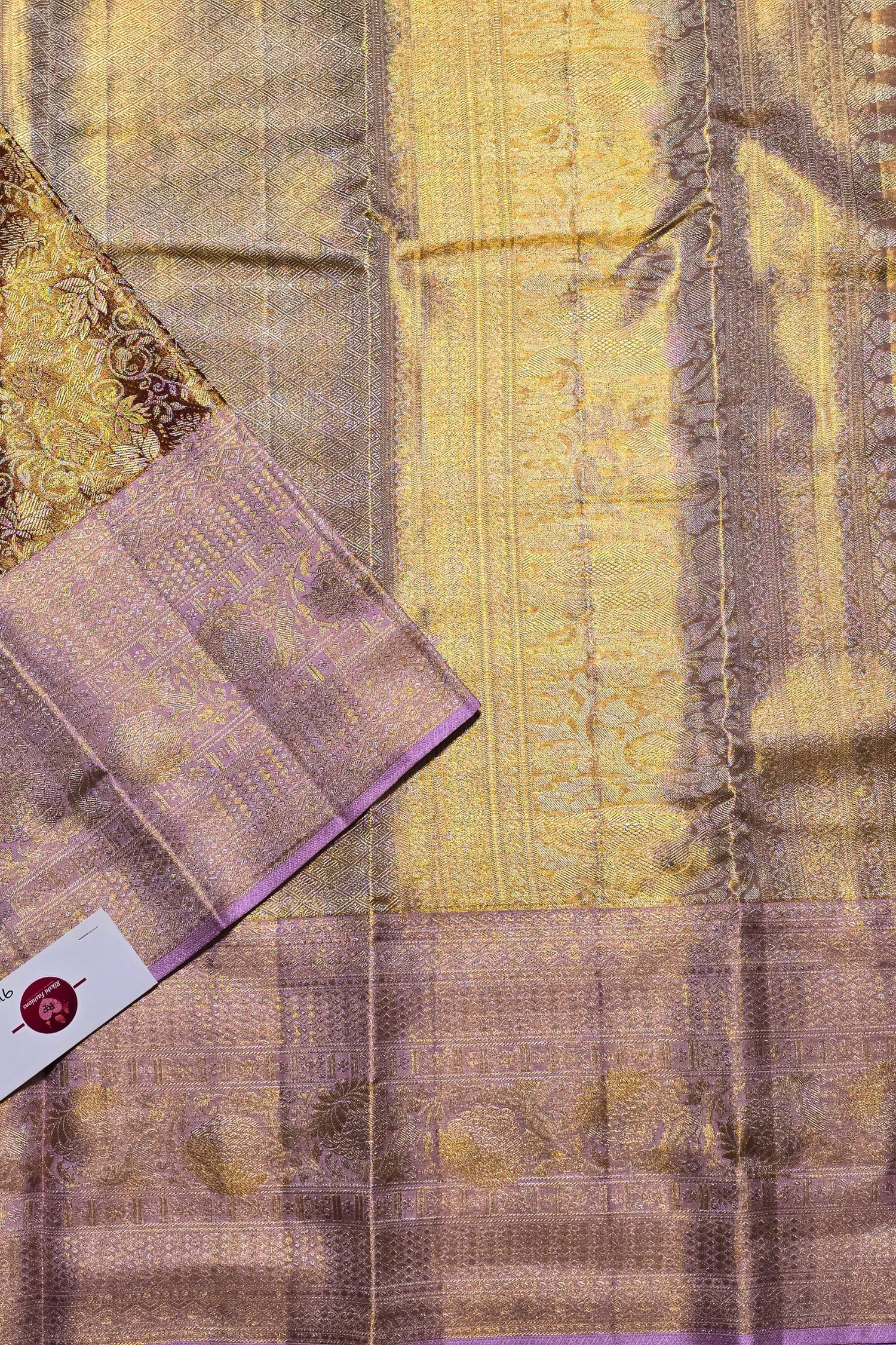 Close-up of a fabric with intricate patterns and textures, featuring gold and purple colors.