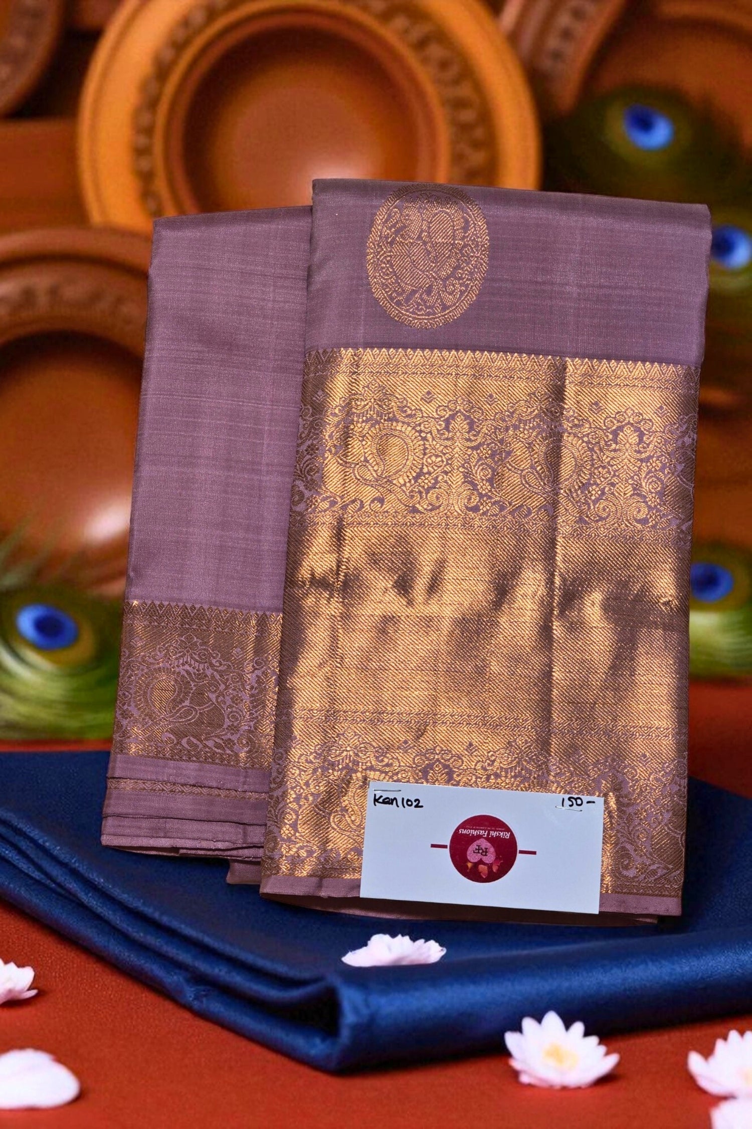 Two pieces of traditional fabric with intricate patterns on a blue cloth, with a price tag visible.