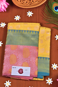 Colorful saree with a price tag on a wooden surface with flowers and a peacock feather.