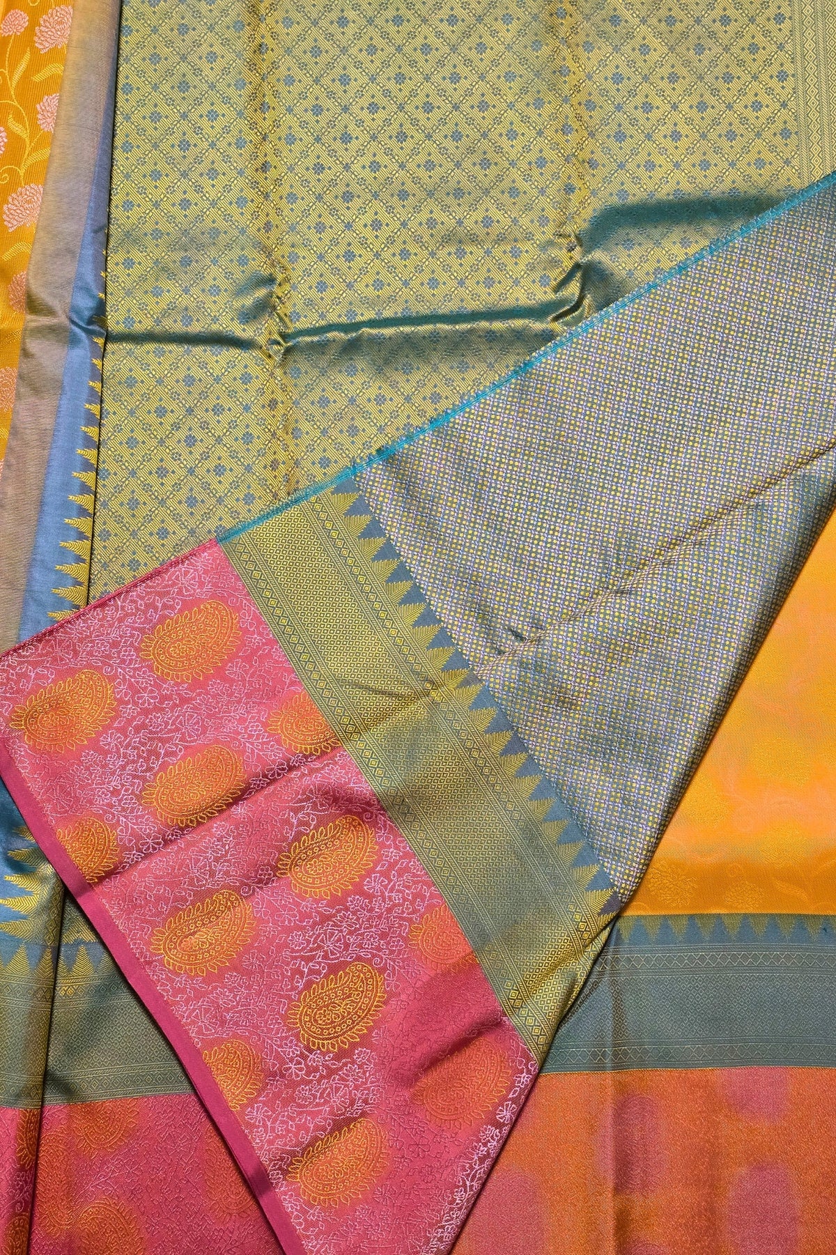 Close-up of a colorful fabric with patterns and a pink section with orange dots.