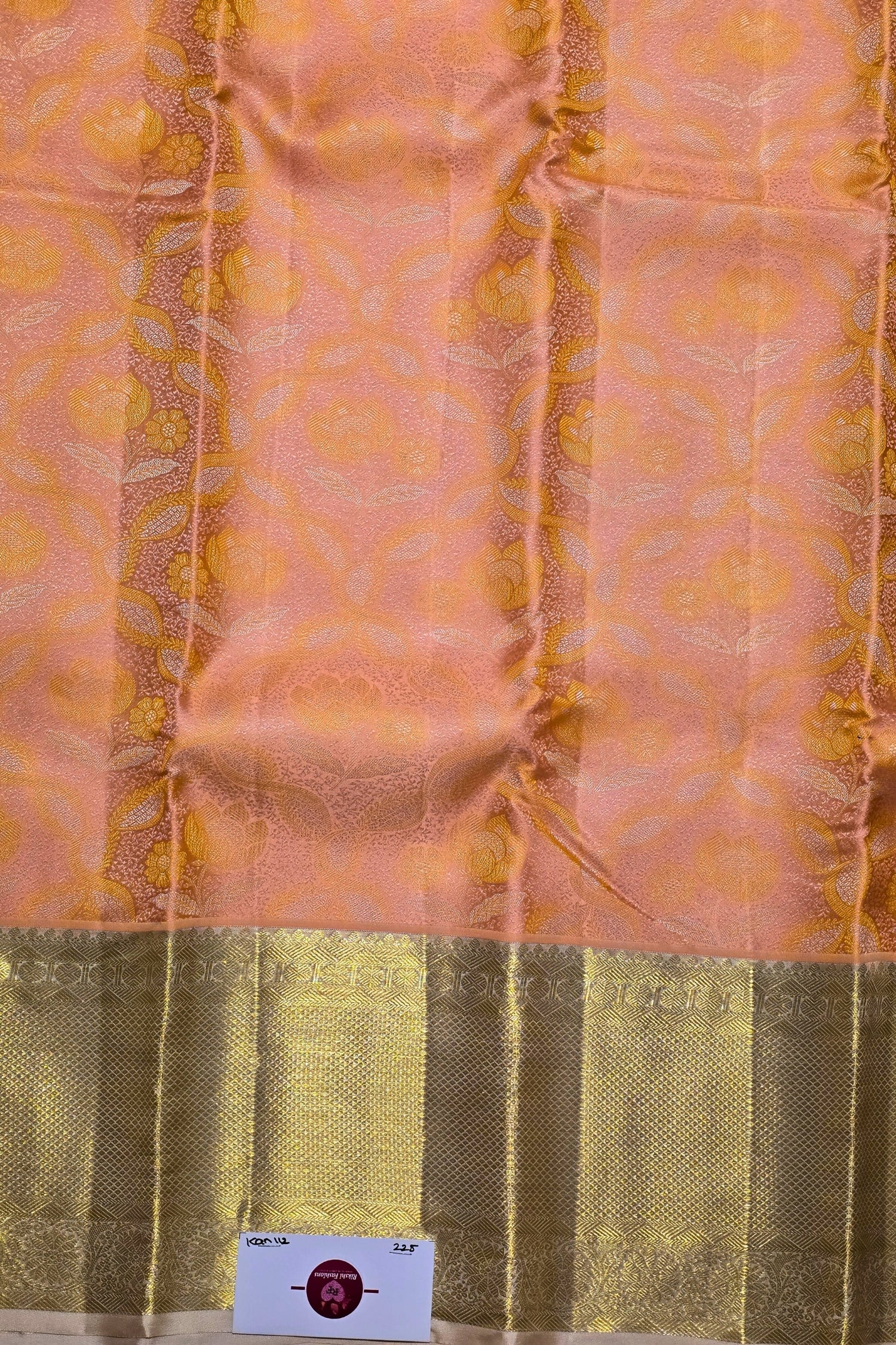 Silk fabric with a patterned design on a peach and green background