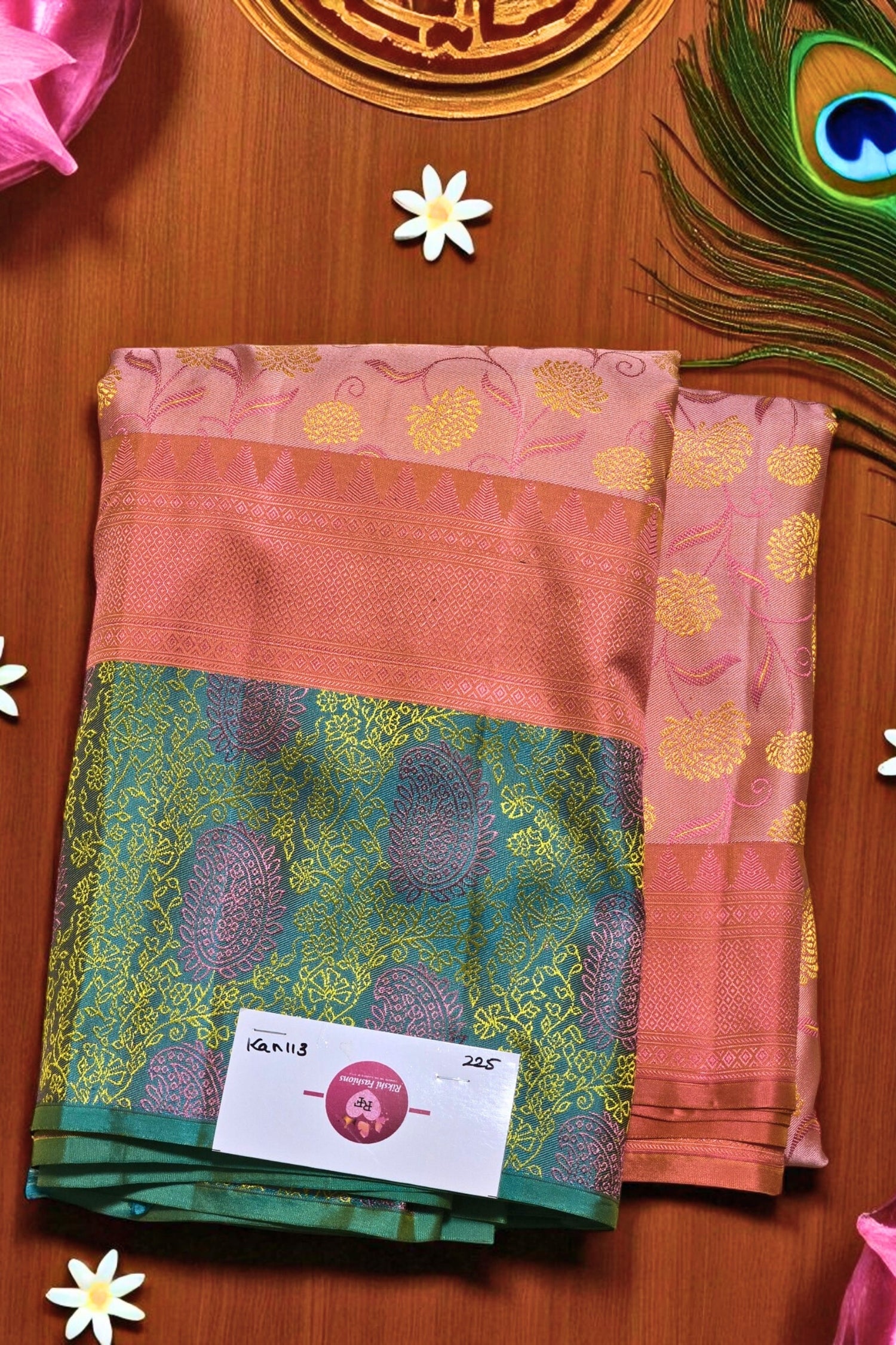 sarees with a brand label on a wooden surface with decorative elements.