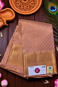 Brown saree with gold border on a wooden surface with decorative items.