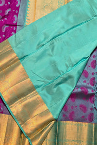 Close-up of a green fabric with gold and pink patterns in the background