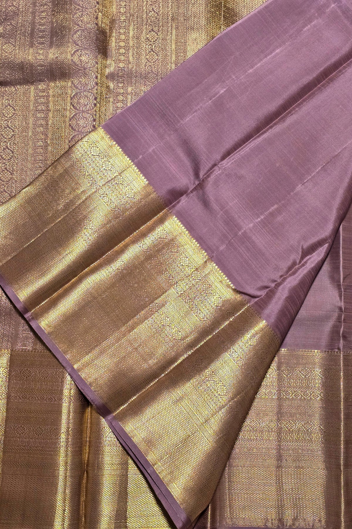 Sari with purple and gold border on a textured fabric background