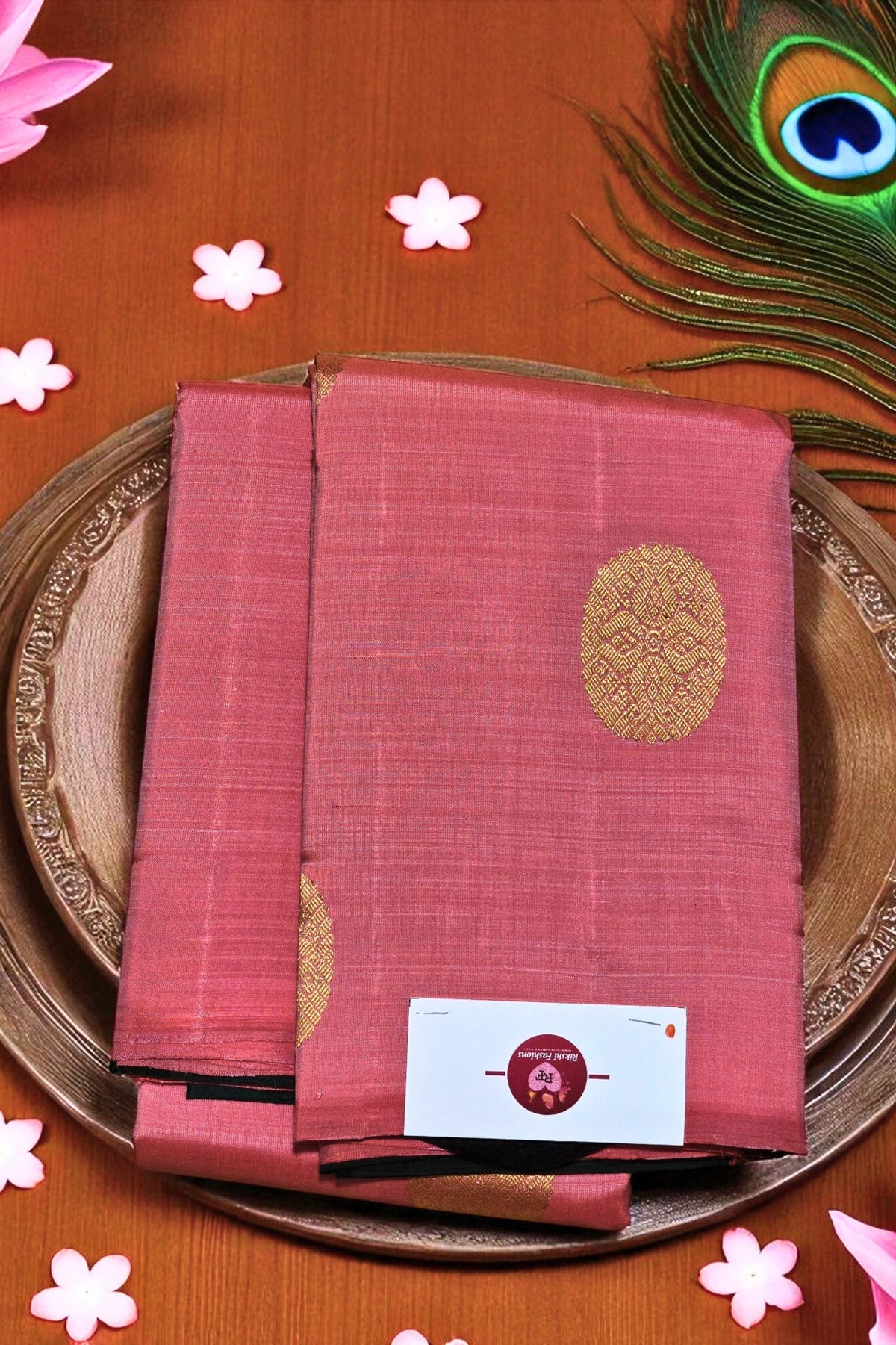 Red saree with gold patterns on a wooden surface with decorative elements