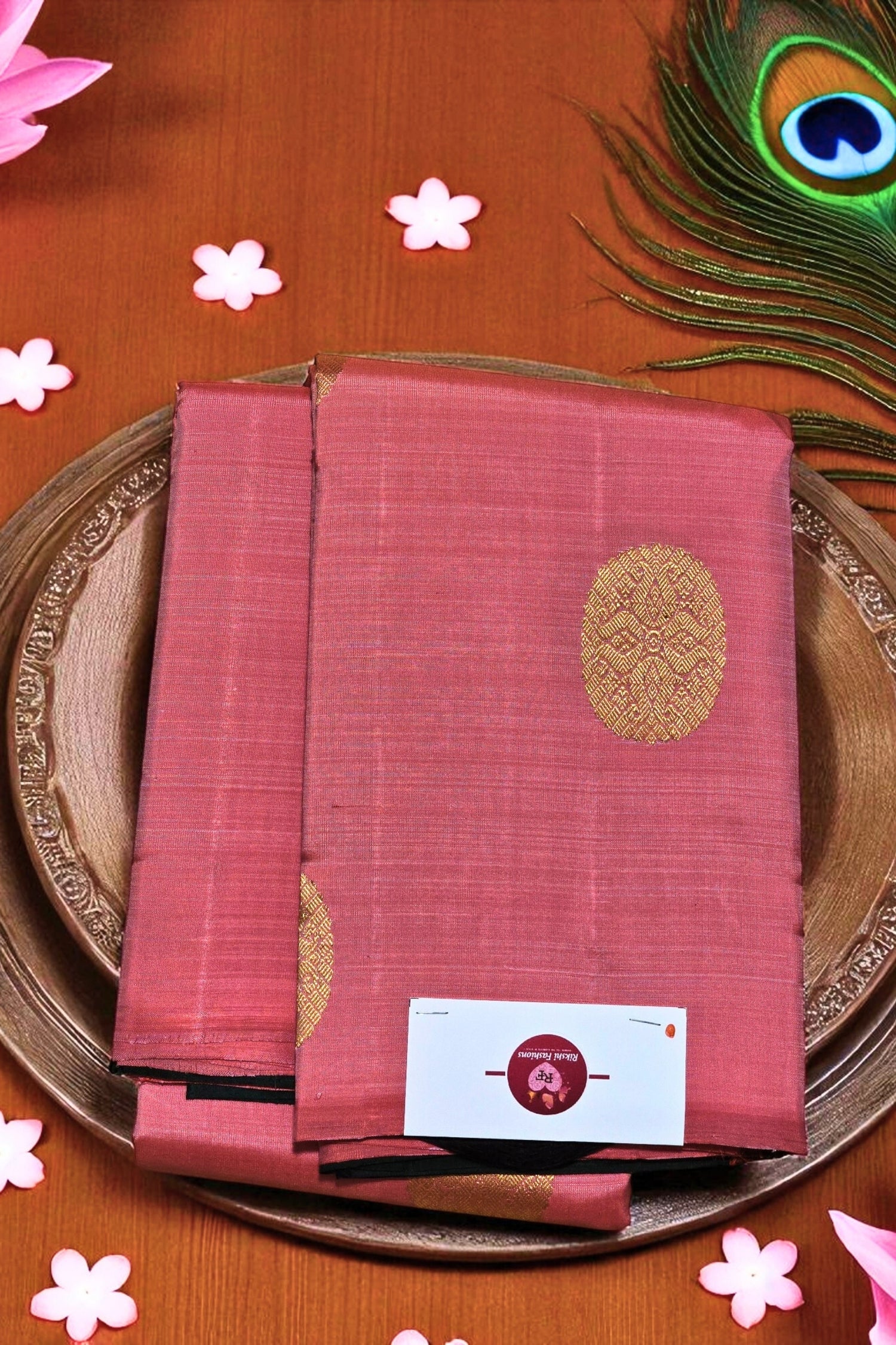 Red saree with gold patterns on a wooden surface with decorative elements
