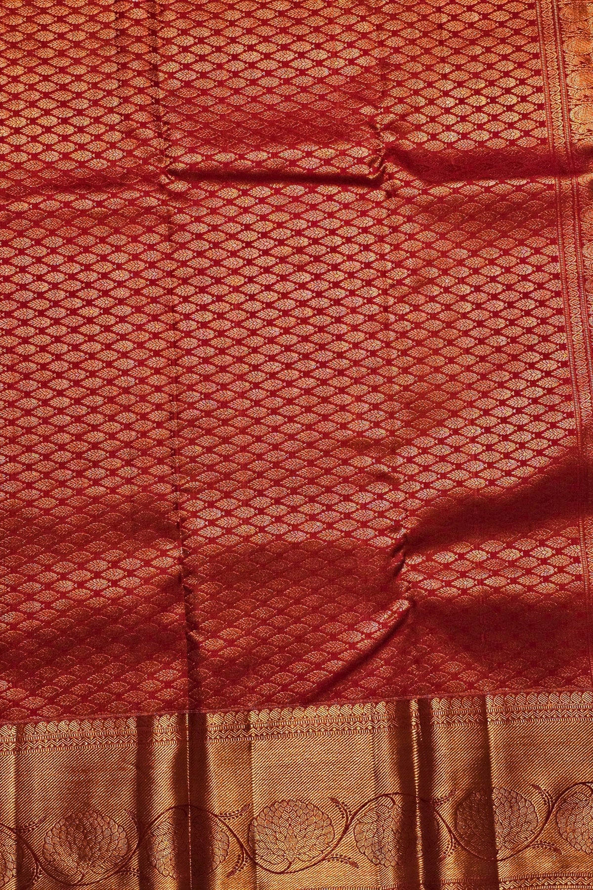 Red fabric with intricate patterns and a gold border