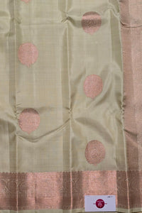 Light green fabric with pink circular patterns and a border, with a visible brand label.
