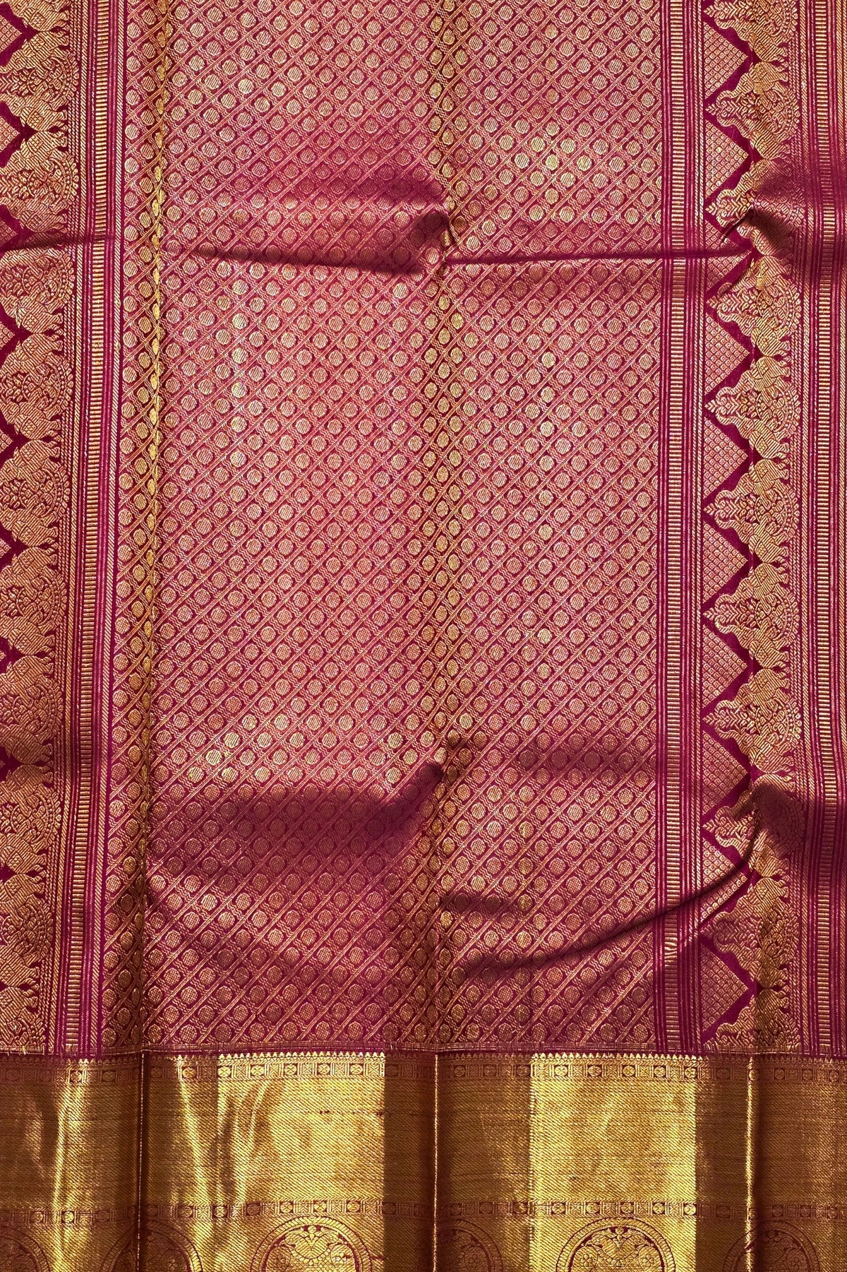 Traditional pink and gold fabric with intricate patterns