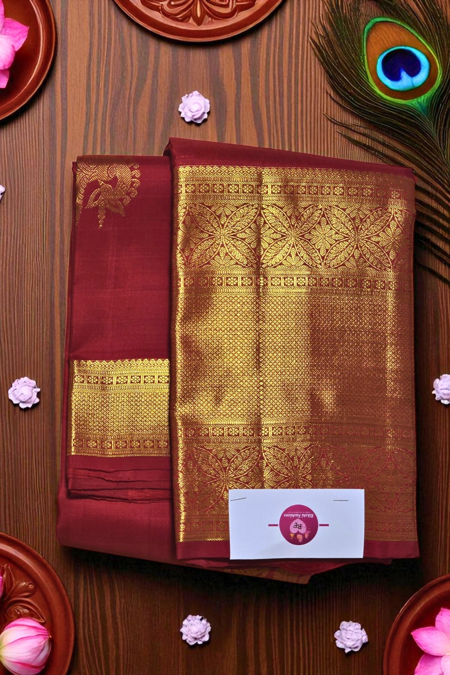 Maroon and gold saree with a brand label on a wooden background