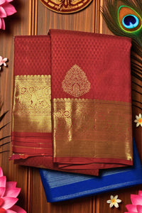 Red saree with gold patterns on a wooden background