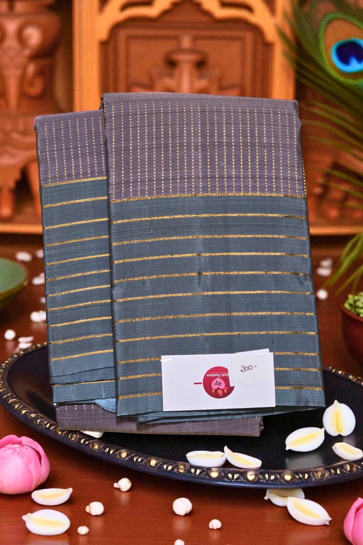 Two folded fabrics with a visible brand label on a decorative plate with flowers and leaves.