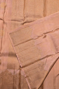 Close-up of a pink saree with gold patterns